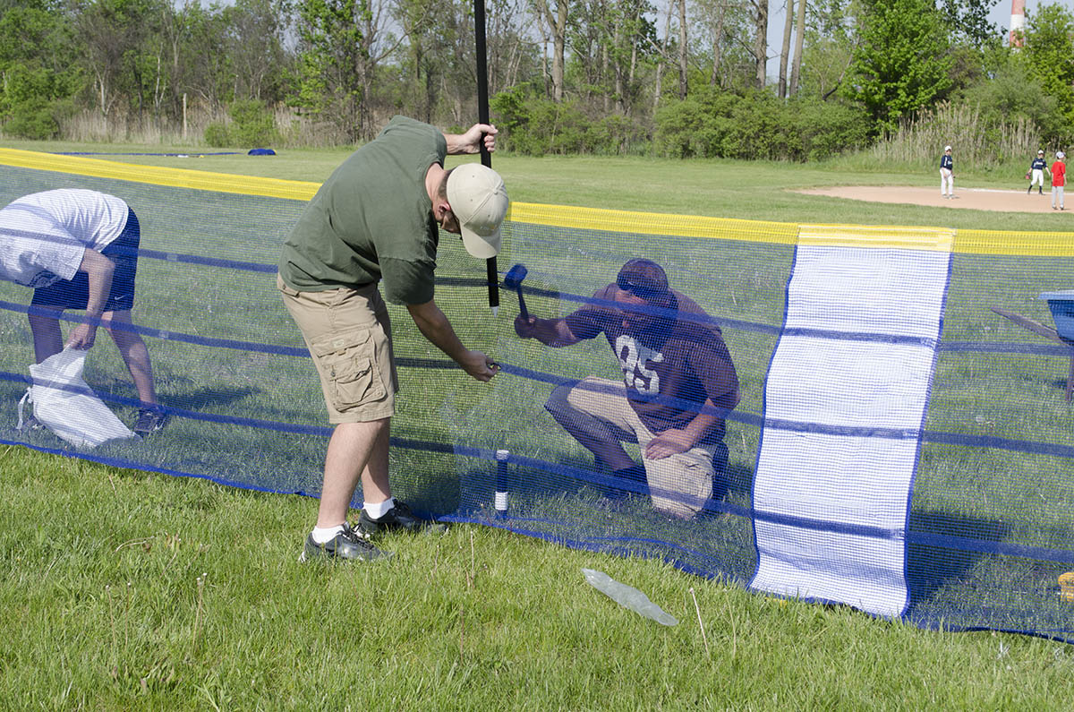 Volunteers install Grand Slam Fencing at Lions Park in Trenton, Michigan.